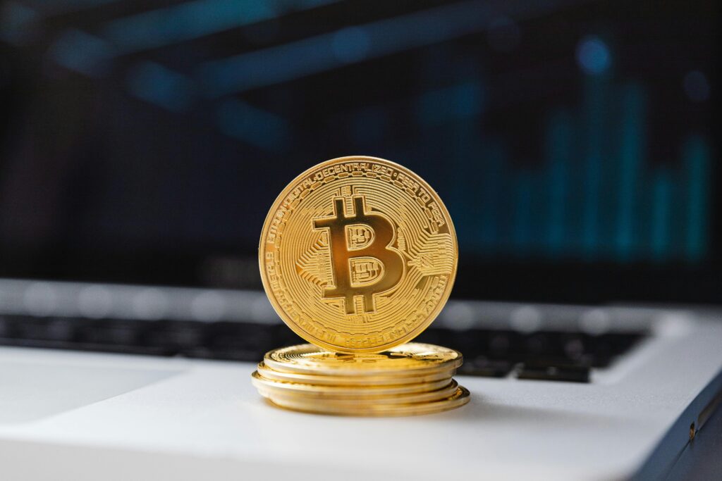 pexels photo 5980738 5980738 A shiny gold Bitcoin coin on laptop keyboard, symbolizing digital currency and blockchain technology.