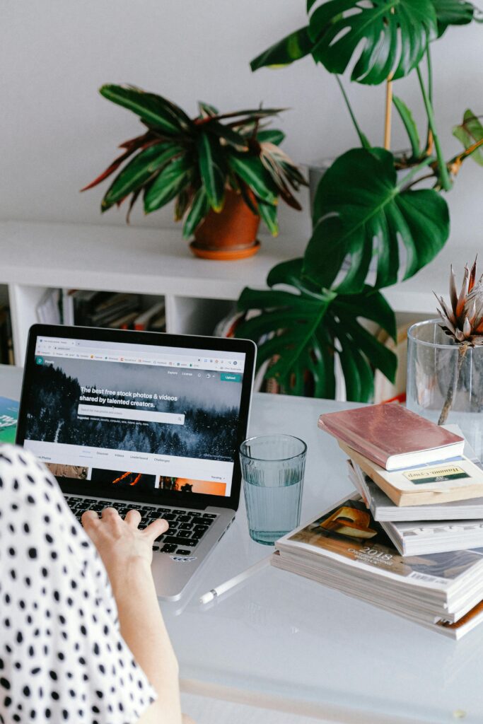 pexels photo 3987020 3987020 A woman working from home on her laptop surrounded by plants and books for a cozy office feel.