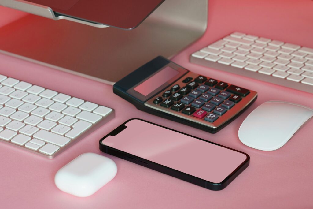 pexels photo 19993820 19993820 A stylish setup of office gadgets on a pink surface, including a smartphone and calculator.